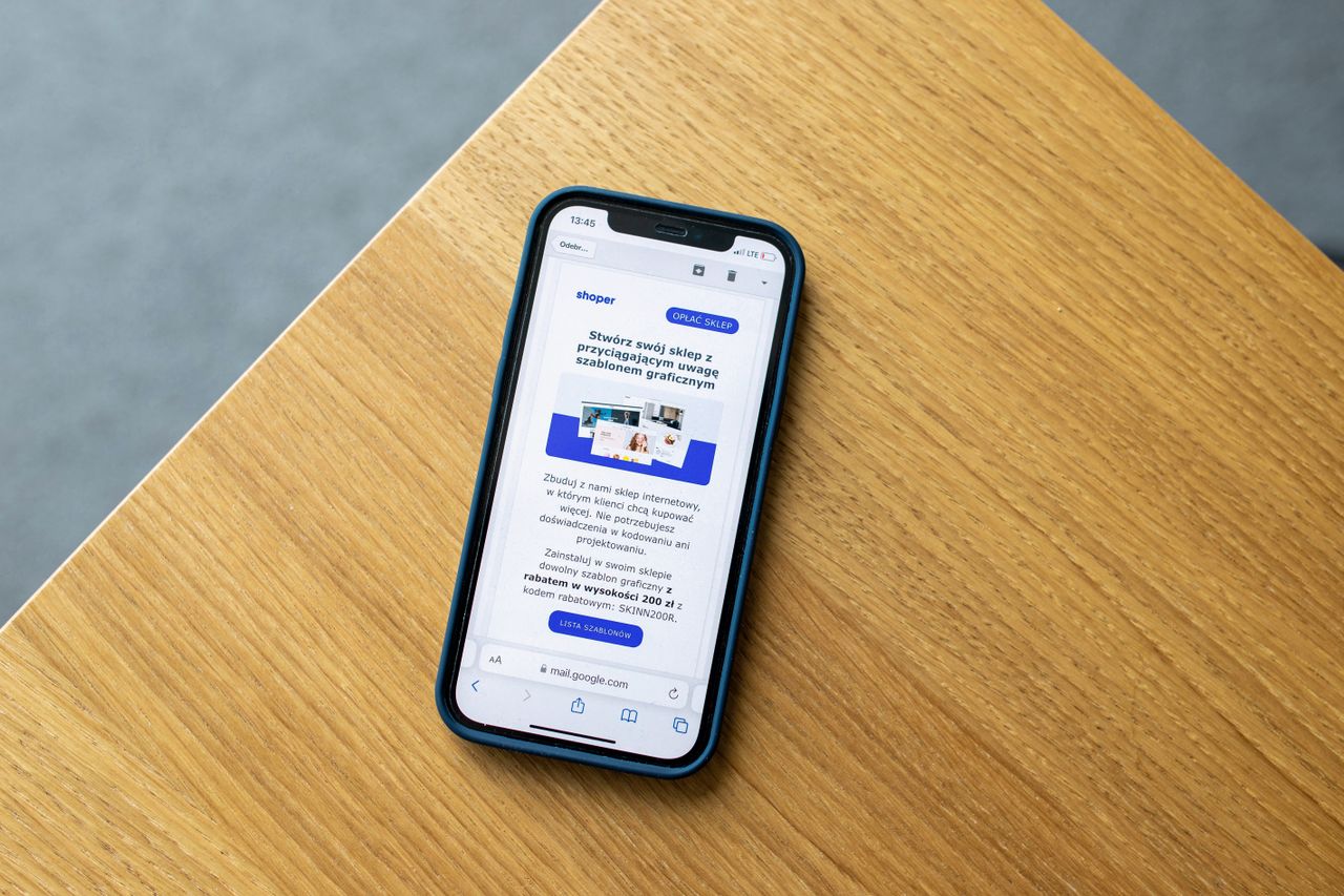 Téléphone mobile affichant une interface e-commerce sur une surface en bois, illustrant la technologie d’achat en ligne.